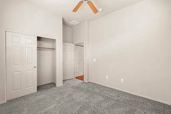 A room with a white door and a grey carpet.