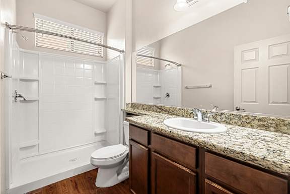 A white bathroom with a toilet, sink, and shower.