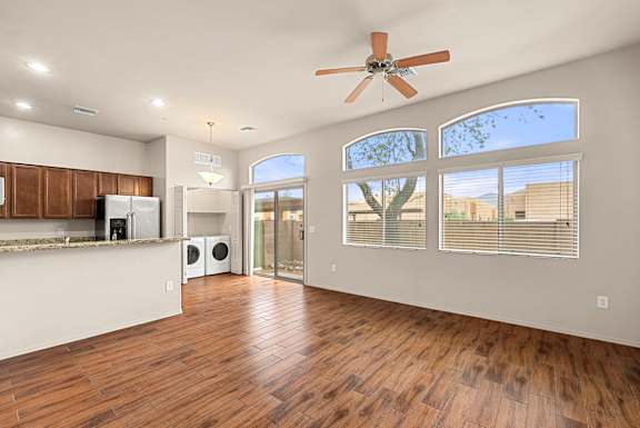 A spacious room with a ceiling fan and wooden flooring.
