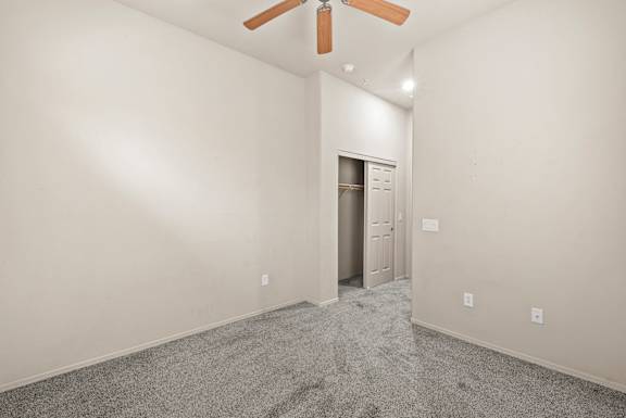 A room with a ceiling fan and a door.
