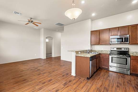 A kitchen with wooden floors and stainless steel appliances.