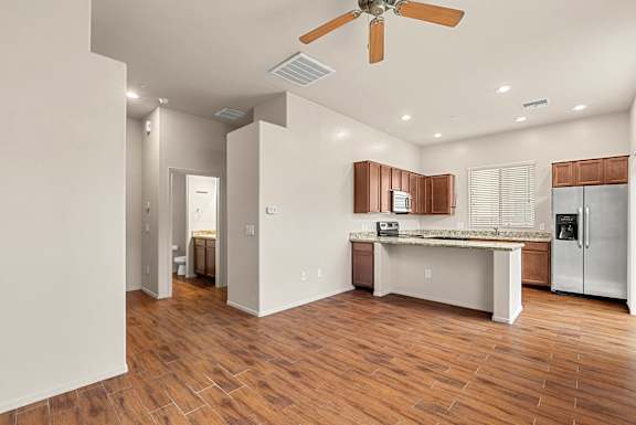 A kitchen with a refrigerator, sink, and countertop.