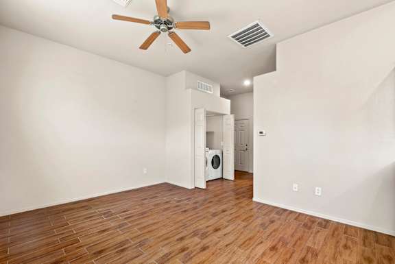 A room with a ceiling fan and a wood floor.