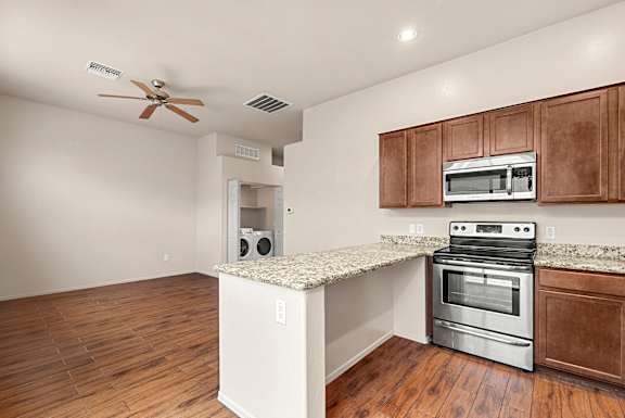 A kitchen with a stove top oven and a microwave above it.