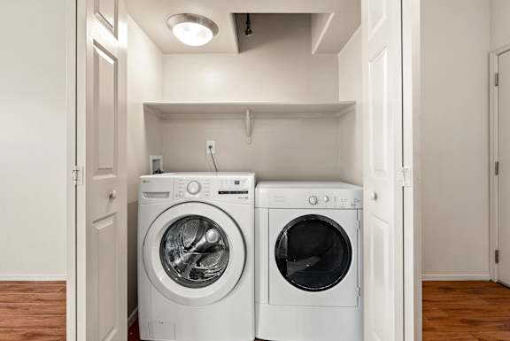 Two front loading washing machines in a small laundry room.