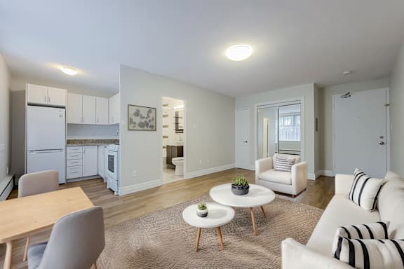 A living room with a white couch and a dining table.