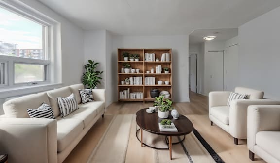 A living room with a white sofa, a wooden coffee table, and a white armchair.  at 391 Sherbourne Apartments, Toronto, Ontario