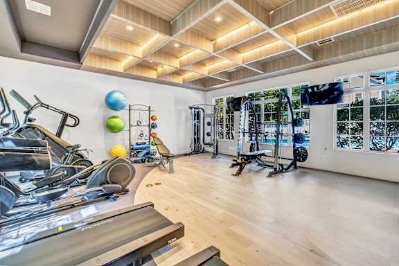 A gym with a variety of exercise equipment including treadmills, stationary bikes, and weight machines. at Ardenwood Apartments, North Haven