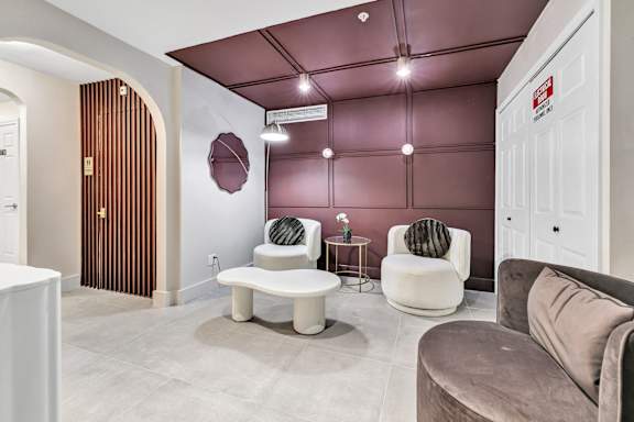 a living room with couches and chairs and a door at The Meriden, 06450