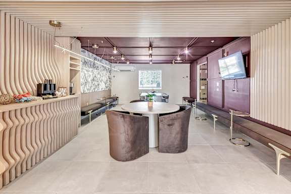 a dining room with a table and a tv at The Meriden, Meriden, CT
