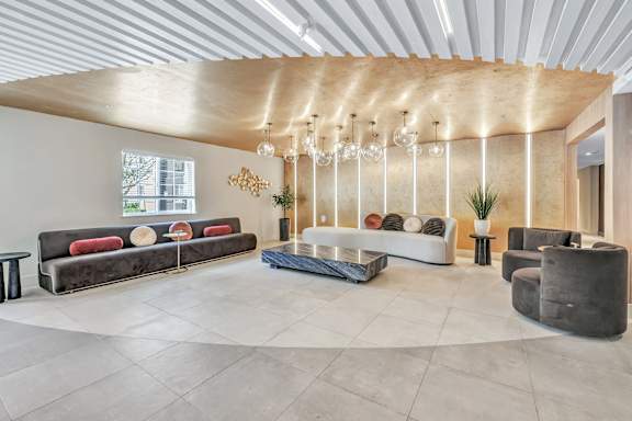 a living room with couches and chairs and a chandelier at The Meriden, Meriden, 06450