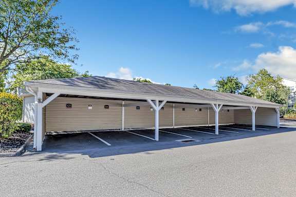 A large, covered parking structure with multiple garage doors. at Ardenwood Apartments, North Haven, Connecticut, 06473