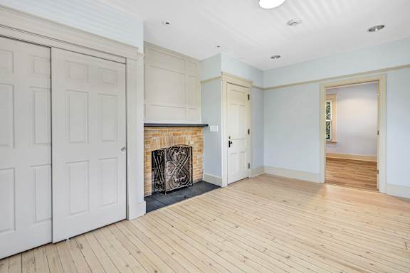 A room with a fireplace and wooden floors. at Ardenwood Apartments, North Haven, CT