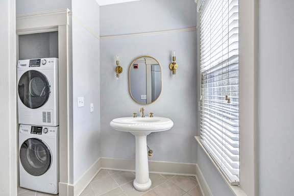 A white bathroom with a washer and dryer in the corner. at Ardenwood Apartments, North Haven, Connecticut, 06473