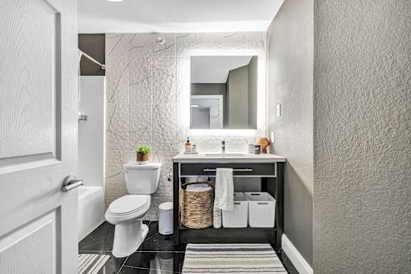 a bathroom with a toilet sink and a mirror
