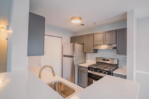 a kitchen with stainless steel appliances and a white counter top
