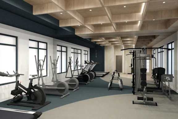 a gym with a lot of equipment and windows at Ardenwood Apartments, North Haven