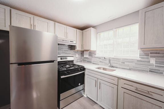 a kitchen with stainless steel appliances and white cabinets at BAY SHORE APARTMENTS, EAST HAVEN, CT, 06512