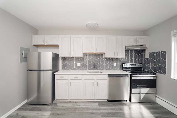 a kitchen with white cabinets and a stainless steel refrigerator