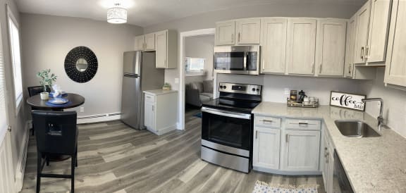 a kitchen with white cabinets and stainless steel appliances at Encore 99, East Haven, 06512