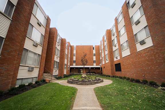 an exterior view of an apartment building with a courtyard at Five High, West Hartford, CT