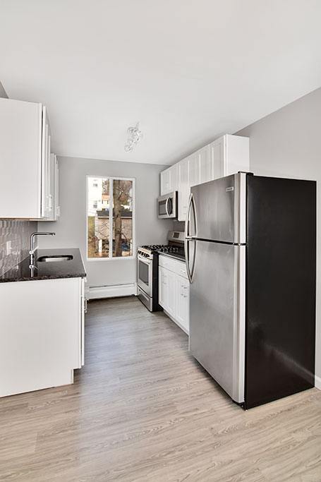 a kitchen with a black refrigerator and white cabinets&#xA0;at Springwood Gardens, New Britain, 06053