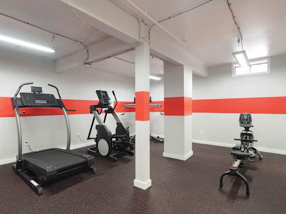 a gym with exercise equipment and a red stripe on the wall at The Packard, West Hartford, 06119