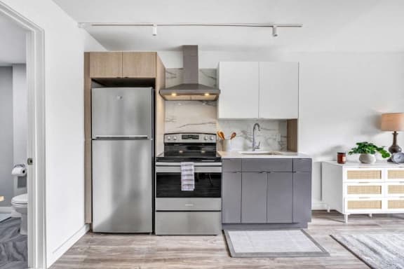 a small kitchen with stainless steel appliances and white cabinets&#xA0;at Up House, Farmington