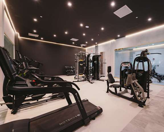 a gym with treadmills and other exercise equipment on a white floor
