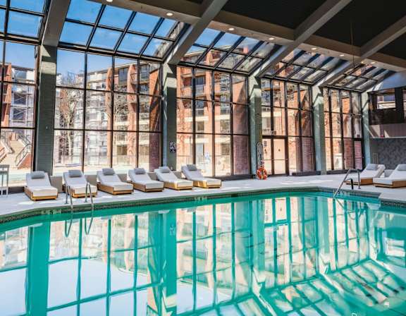 a swimming pool in front of a building with large windows at Up House, Connecticut