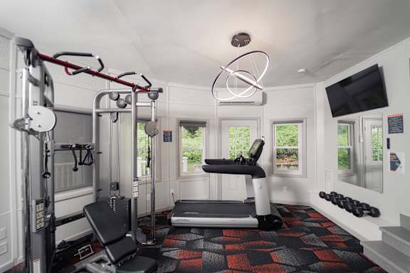 a home gym with exercise equipment and a tv at Woodbury, Woodbury, CT