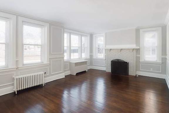 a living room with a wood floor and a fireplace