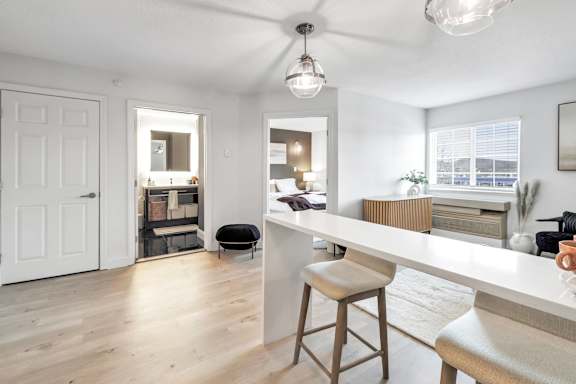 an open kitchen and living room with a white counter top
