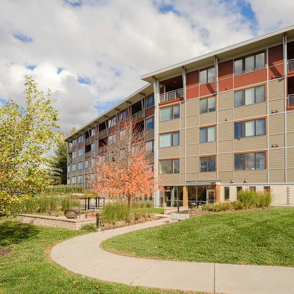 A large apartment building with a walkway in front of it.