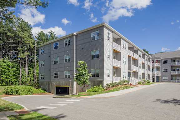 A large apartment complex with a parking lot in front.