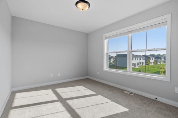 a living room with a large window and carpet