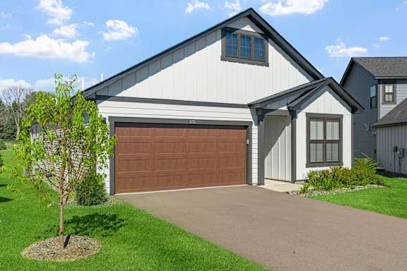 A white house with a brown garage door.