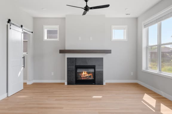 a living room with a fireplace and a ceiling fan