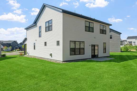 A modern house with a grey exterior and a black roof.