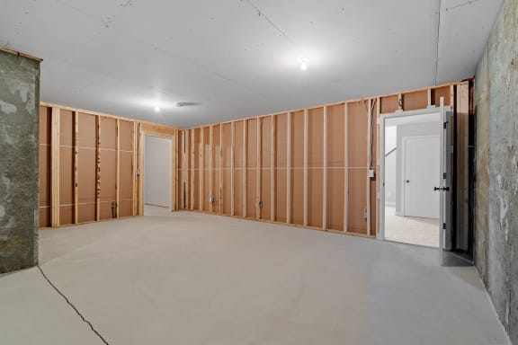the living room is being remodeled and has wood walls and a concrete floor