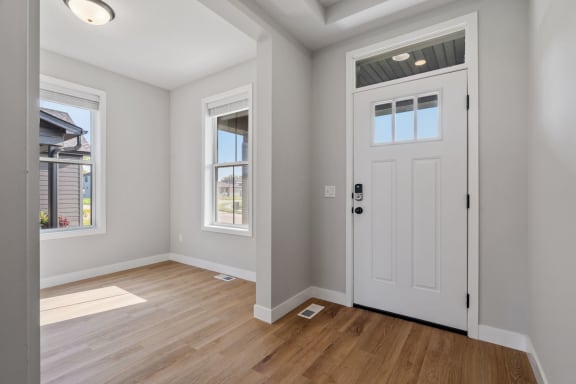 an empty room with a white door and a window