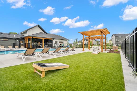 A sunny day at the pool with lounge chairs and a gazebo.