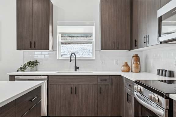 A kitchen with brown cabinets and a white countertop.