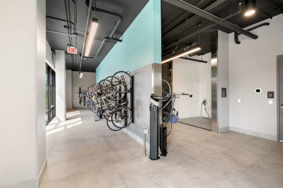 a collection of bikes in a room with a turquoise accent wall
