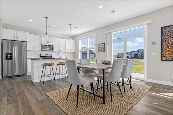 A modern kitchen with a dining table and chairs.