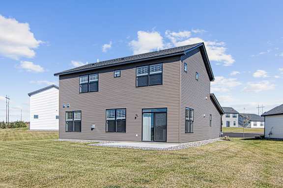 A modern house with a grey facade and a black roof.