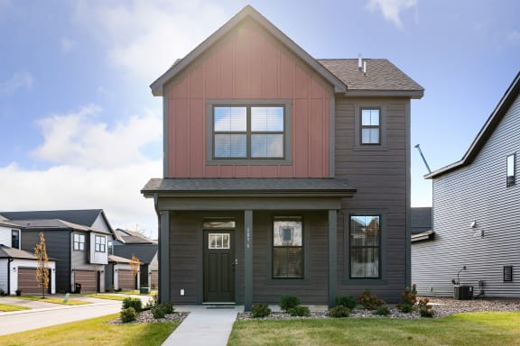 the front of a house with a sidewalk in front of it