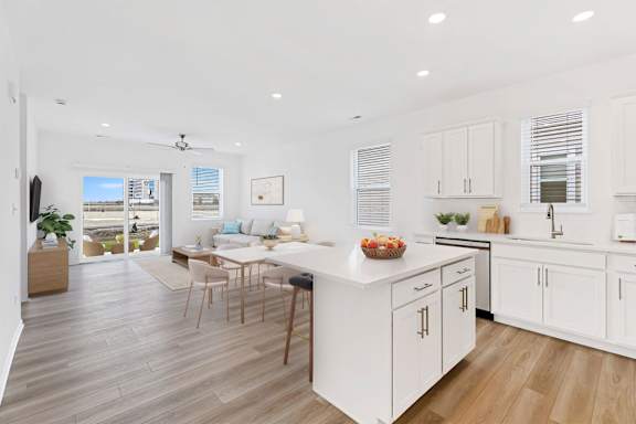 A modern kitchen with white cabinets and a wooden island.