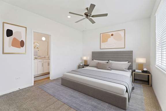 A bedroom with a large bed and a ceiling fan.