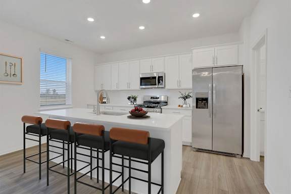 A kitchen with a white countertop and stainless steel appliances.